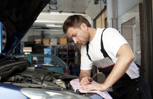 Auto mechanic checking car in service