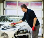 Man worker washing luxury car with sponge on a car wash