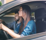 Driving test. Young serious woman driving car feeling inexperienced, looking nervous at the road traffic for information to make appropriate decisions. Man is an instructor, controlling and checking