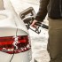 Man filling snow covered diesel car gas tank at the fuel pump, d