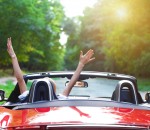 Beautiful blond young woman driving a sports car