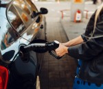 Woman with gun fuels vehicle on gas station