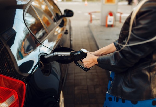 Woman with gun fuels vehicle on gas station