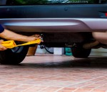 Hands of man holding yellow car towing strap with car.